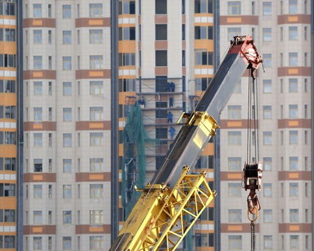 Building crane at the background of a multi-storey building under constructionの写真素材