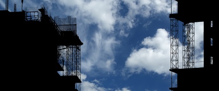 Silhouette of construction, construction equipment and elements of the building under construction on the sky backgroundの写真素材