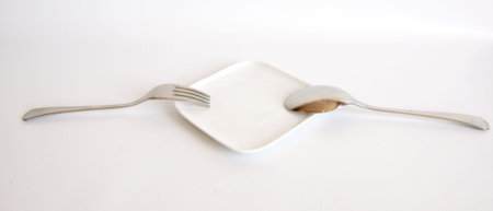 Fork and spoon on a white plate and white