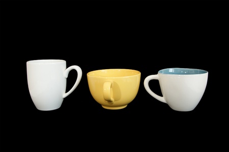 Three large white and yellow cup closeup isolated on blackの写真素材
