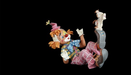 Figurine good funny clown with a small dog, isolated on blackの写真素材