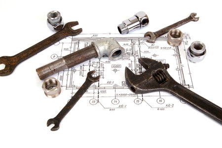 Plumbing parts and tools on the drawing, close-up