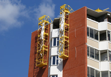 Fragment of a residential apartment building under construction on a background of blue sky