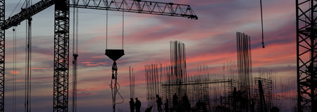 silhouettes of construction workers, construction equipment and elements of a building under construction at Sunsetの写真素材
