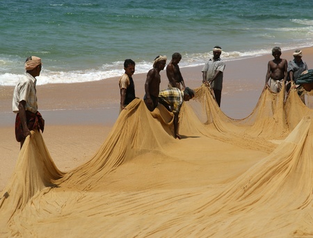 KOVALAM, INDIA, MARCH 14: Kovalam, Kerala, South India,  March 14, 2011.  Fishermen are pulling their fishing net in combined work out of the sea のeditorial素材