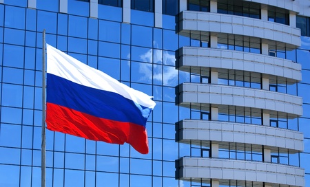 Russian flag on the background of the windows of office buildingの写真素材