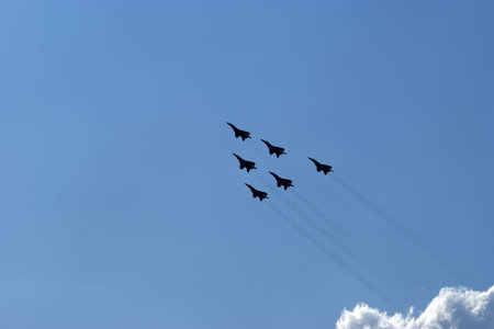 Flight of modern combat fighters on the sky background