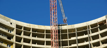 Building crane at the background of building under construction