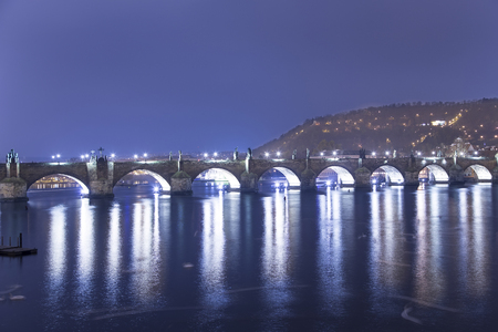 A night view of the river Vltava and Charles Bridge in Prague, Czech Republicの写真素材