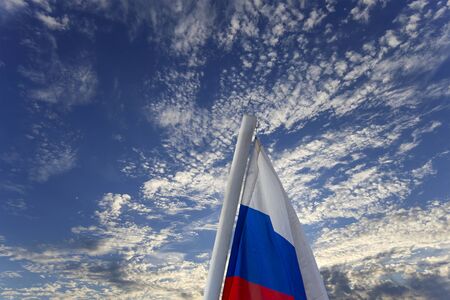 Russia flag waving in the wind against the sky. Three colors of Russian wavy flag as a patriotic symbolの写真素材