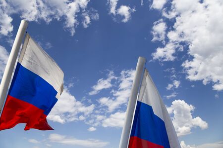 Russia flag waving in the wind against the sky. Three colors of Russian wavy flag as a patriotic symbolの写真素材
