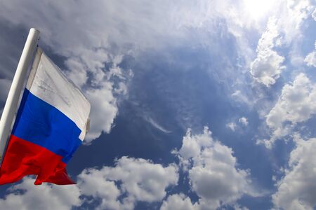 Russia flag waving in the wind against the sky. Three colors of Russian wavy flag as a patriotic symbolの写真素材