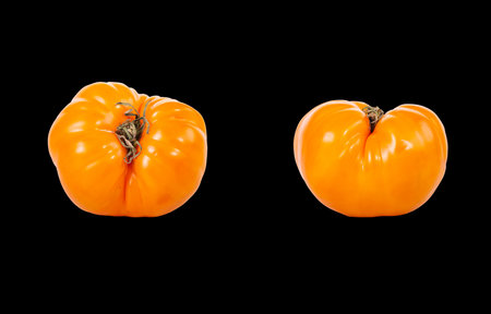 Still life with fresh yellow tomatoes on black background 
