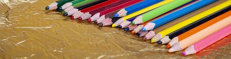 Assortment of coloured pencils on yellow (gold) background   の写真素材