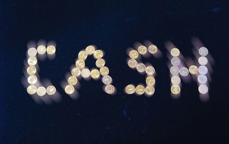 Cash sign, lined with 10-ruble coins on black backgroundの写真素材