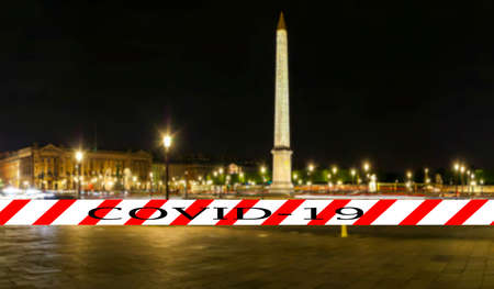 Coronavirus in Paris, France. Covid-19 sign on a blurred background. Concept of COVID pandemic and travel in Europe. Place de la Concorde and  Obelisk of Luxor at nightのeditorial素材