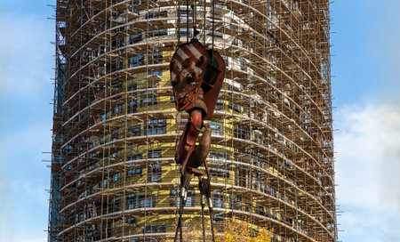 Construction crane hook with multi-storey building under construction with scaffolding (new...