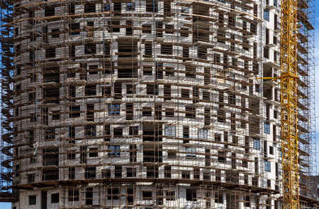 Multi-storey building under construction with scaffolding (new residential complex), Moscow, Russiaの写真素材