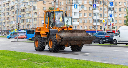 A heavy yellow road excavator on the road in the city. Moscow, Russia