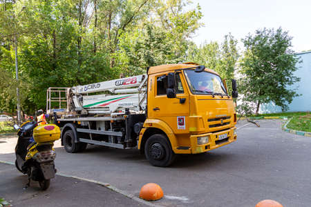 A car with a hydraulic lift plant in the courtyard of a residential building.The work of city utilities, Moscow, Russiaのeditorial素材