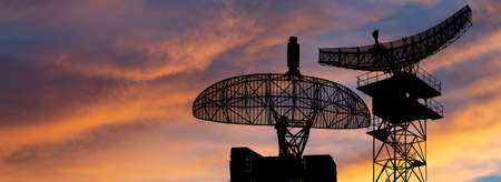 Air defense radars of military mobile anti aircraft systems, modern army industry on the background of the sunset orange sky, Russiaの写真素材