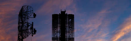 Air defense radars of military mobile anti aircraft systems (radar is designed and automatic tracking of targets and missiles) , on the background of the sunset orange sky, Russiaの写真素材