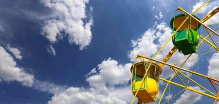Attraction (carousel) ferris wheel on the background of the cloudy skyの写真素材