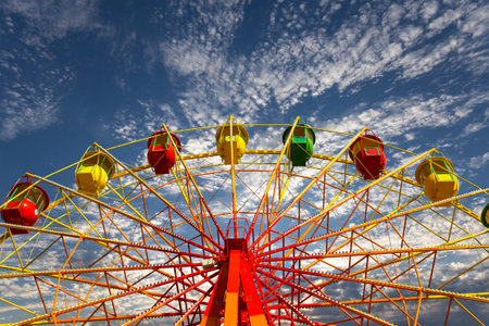 Attraction (carousel) ferris wheel on the background of the cloudy skyの写真素材
