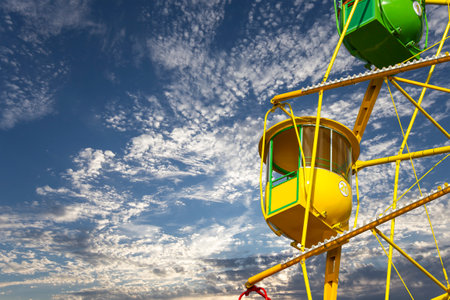 Attraction (carousel) ferris wheel on the background of the cloudy skyの写真素材