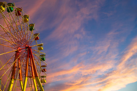 Attraction (carousel) ferris wheel against the background of a romantic evening skyの写真素材