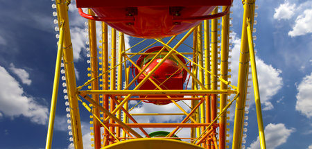 Attraction (carousel) ferris wheel on the background of the cloudy skyの写真素材