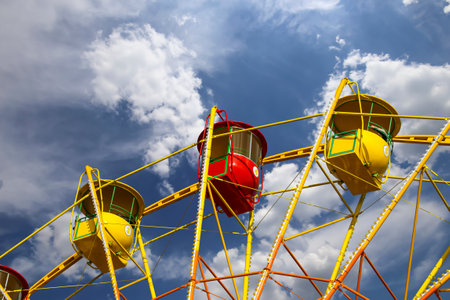 Attraction (carousel) ferris wheel on the background of the cloudy skyの写真素材