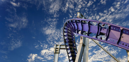 Attraction roller-coaster (switchback) on the background of the cloudy skyの写真素材