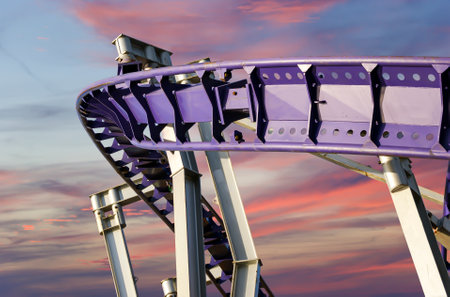 Attraction roller-coaster (switchback) against the background of a romantic evening skyの写真素材