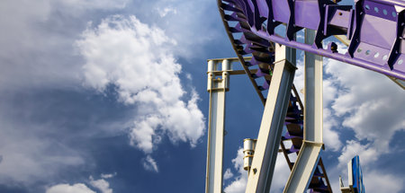 Attraction roller-coaster (switchback) on the background of the cloudy skyの写真素材