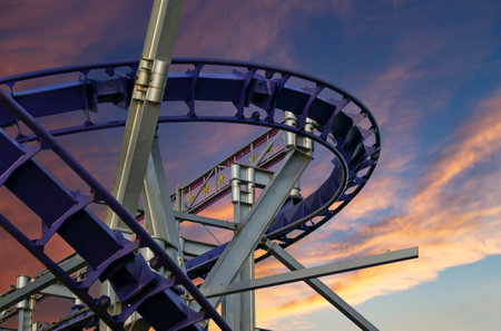 Attraction roller-coaster (switchback) against the background of a romantic evening skyの写真素材