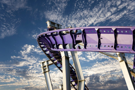 Attraction roller-coaster (switchback) on the background of the cloudy skyの写真素材