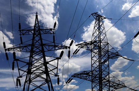 Electricity pylon (high voltage power line), black contour, on the background of the cloudy skyの写真素材