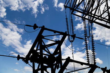 Electricity pylon (high voltage power line), black contour, on the background of the cloudy sky