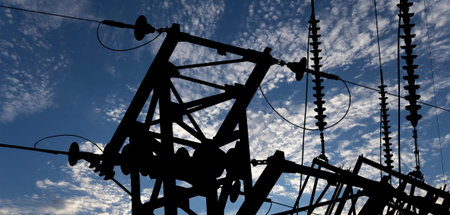 Electricity pylon (high voltage power line), black contour, on the background of the cloudy sky