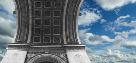 Arc de Triomphe (against the background of sky with clouds), Paris, France. The walls of the arch are engraved with the names of 128 battles and names of 660 French military leaders (in French)の写真素材