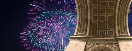Celebratory colorful fireworks over the Arc de Triomphe, Paris, France. The walls of the arch are engraved with the names of 128 battles and names of 660 French military leaders (in French)の写真素材