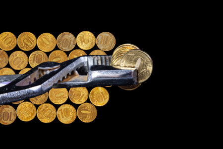 Allegory of the global financial crisis - Iron 10 rubles coin (written ten rubles, Bank of Russia in the Russian) in the grip of economic crisis, on a black background. Finance and business conceptの写真素材