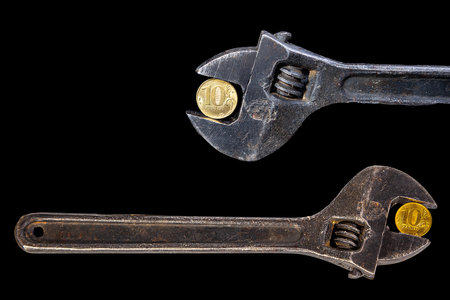 Allegory of the global financial crisis - Iron 10 rubles coin (written ten rubles, Bank of Russia in the Russian) in the grip of economic crisis, on a black background. Finance and business conceptの写真素材