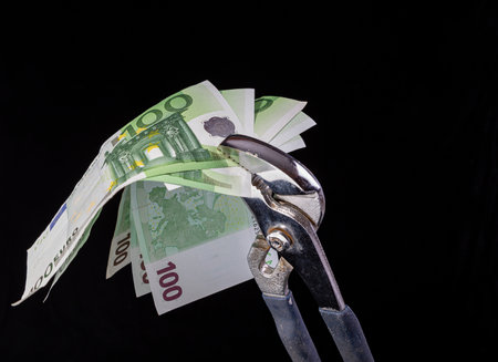 Allegory of the global financial crisis - EURO in the grip of economic crisis, on a black backgroundの写真素材