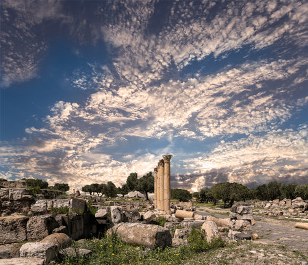 Roman ruins at Umm Qais (Umm Qays)--is a town in northern Jordan near the site of the ancient town of Gadara, Jordan. Against the background of a beautiful sky with cloudsの写真素材