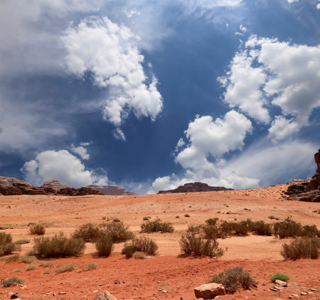Wadi Rum Desert also known as The Valley of the Moon (against the sky with clouds)-- is a valley cut...