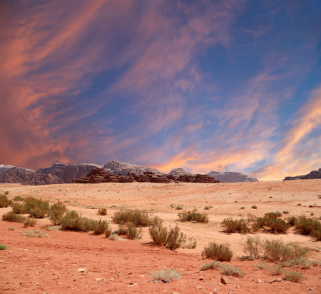 Wadi Rum Desert also known as The Valley of the Moon (against the sky with clouds)-- is a valley cut into the sandstone and granite rock in southern Jordan 60 km to the east of Aqabaの写真素材