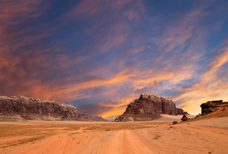 Wadi Rum Desert also known as The Valley of the Moon (against the sky with clouds)-- is a valley cut into the sandstone and granite rock in southern Jordan 60 km to the east of Aqabaの写真素材