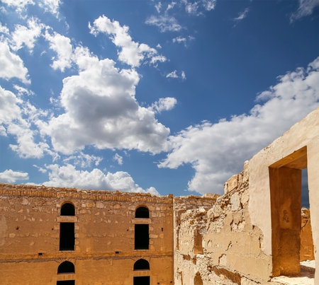 Qasr Kharana (Kharanah or Harrana)-- desert castle in eastern Jordan (100 km of Amman). Built in 8th century AD to be used as caravanserai, a resting place for traders. Against the sky with cloudsの写真素材